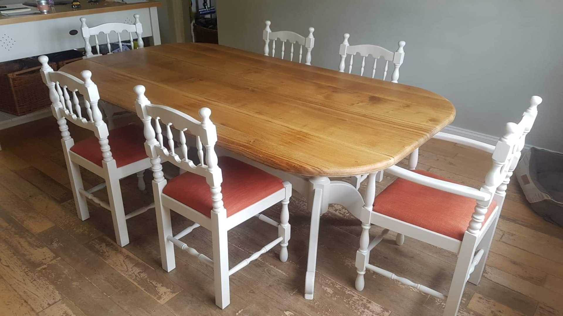 Wooden table and chairs with white legs and red fabric seats