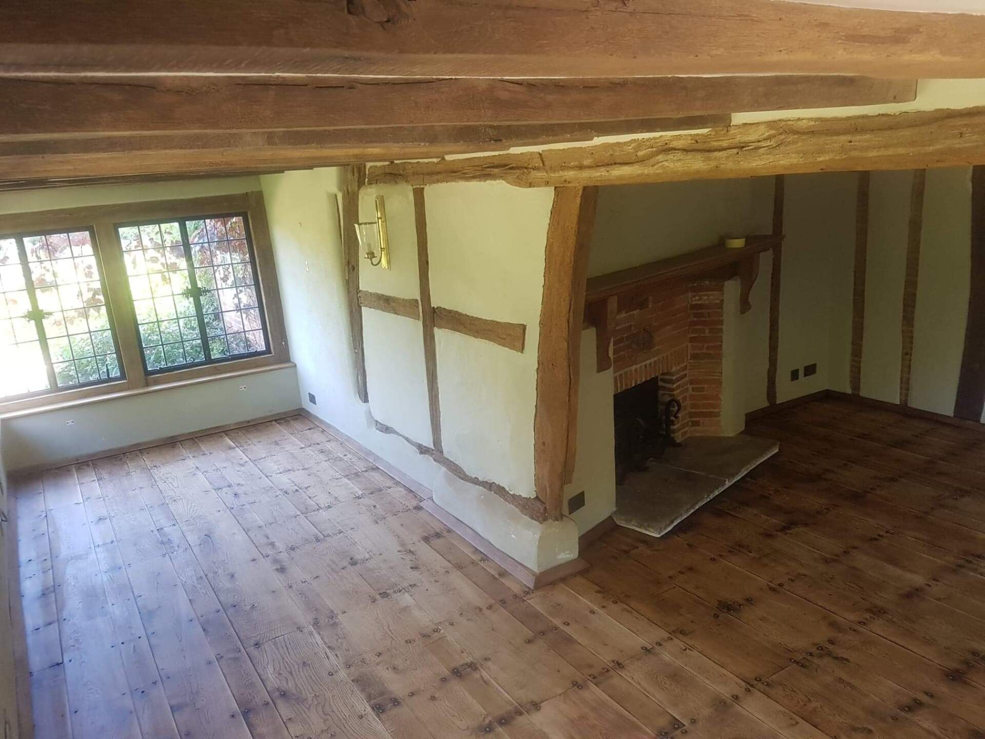 Restored black old original oak floor stained and finished to match beams
